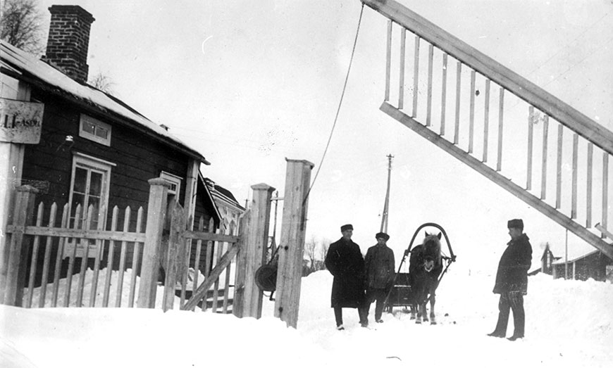 Tornion tulliaseman rakennus, aita ja siinä oleva portti sekä tullimiehiä, rajanylittäjiä, hevonen ja reki.