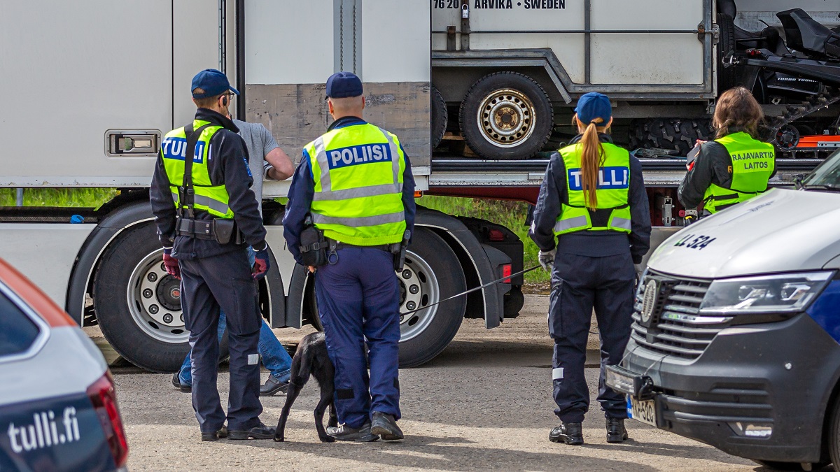 Poliisin, Tullin ja Rajavartiolaitoksen työntekijöitä katsomassa rekan kyydissä olevaa kuormaa.