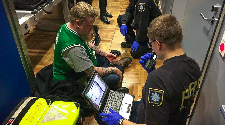 Tartuntautiharjoitus Helsinki-Vantaa lentoasemalla. Pelastushenkilöstö tutkii potilasta. 