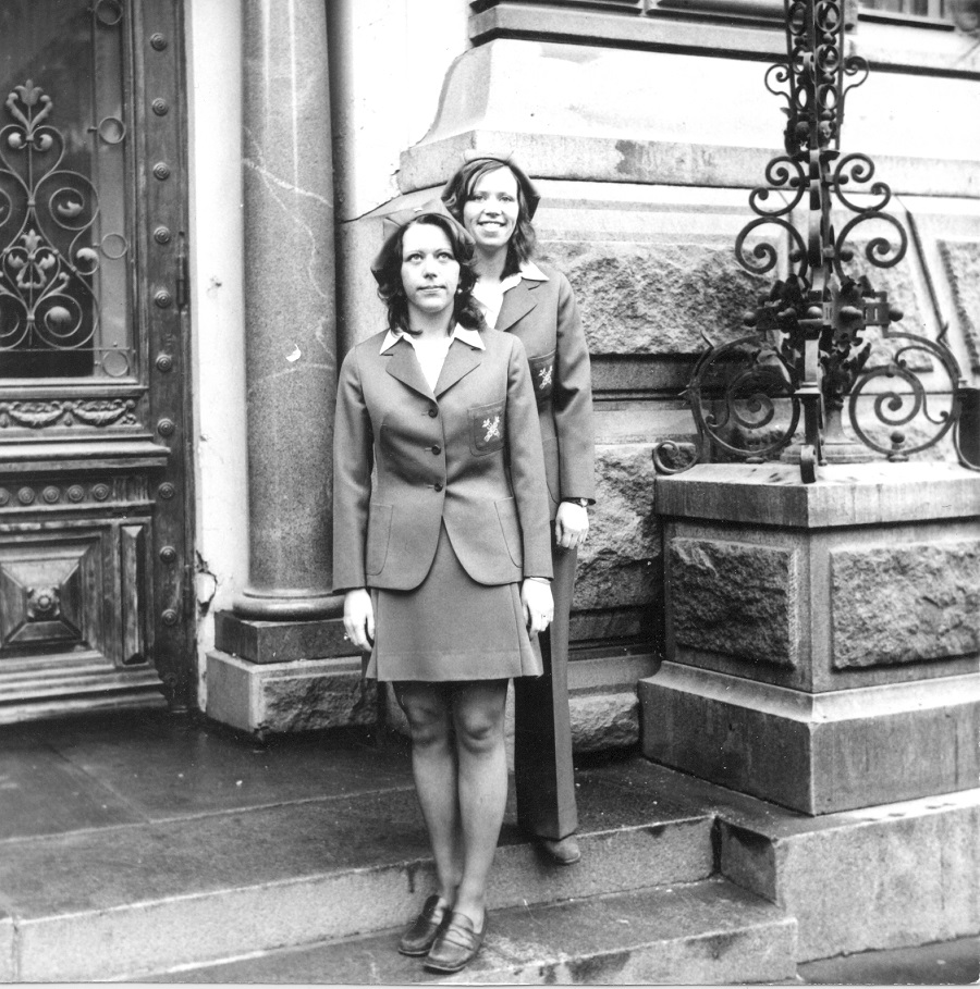 Ritva ja Riitta Arrela seisovat virka-asuissa Tullihallituksen portailla mustavalkoisessa valokuvassa.