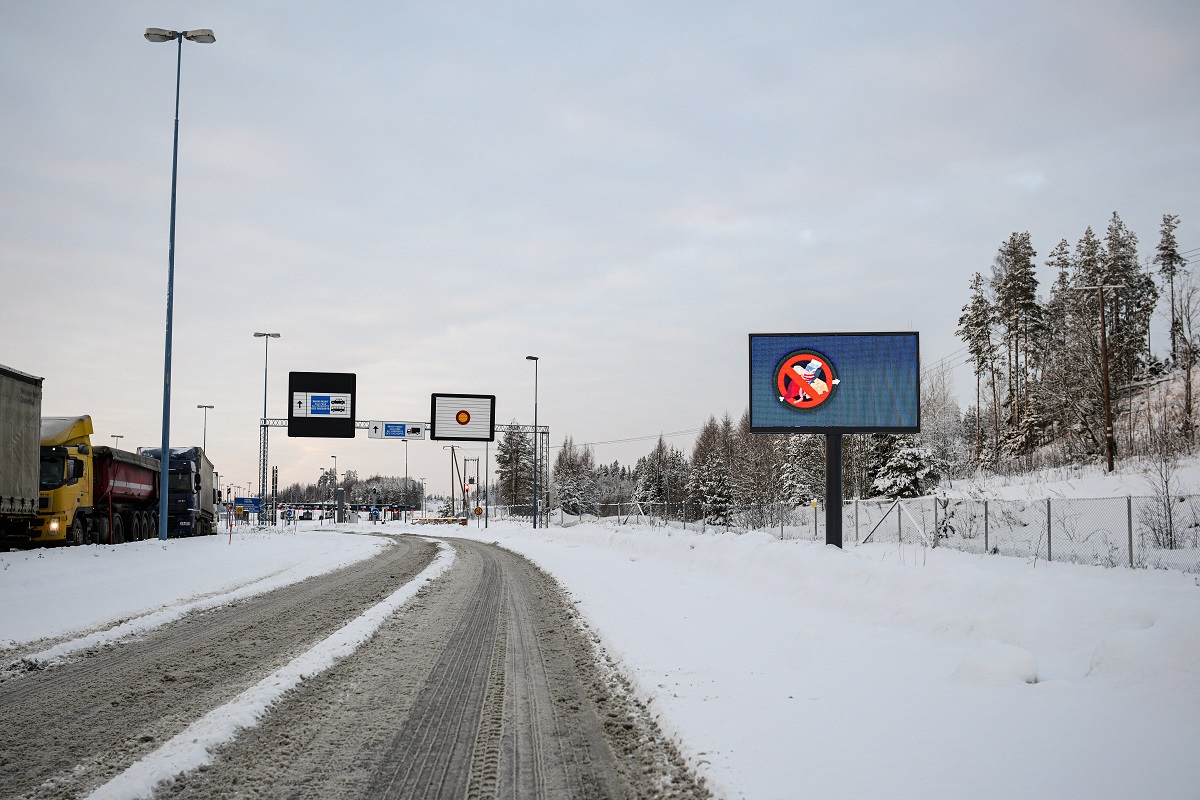 En snöig och tom väg som leder till tullen och gränsövergångsstället.