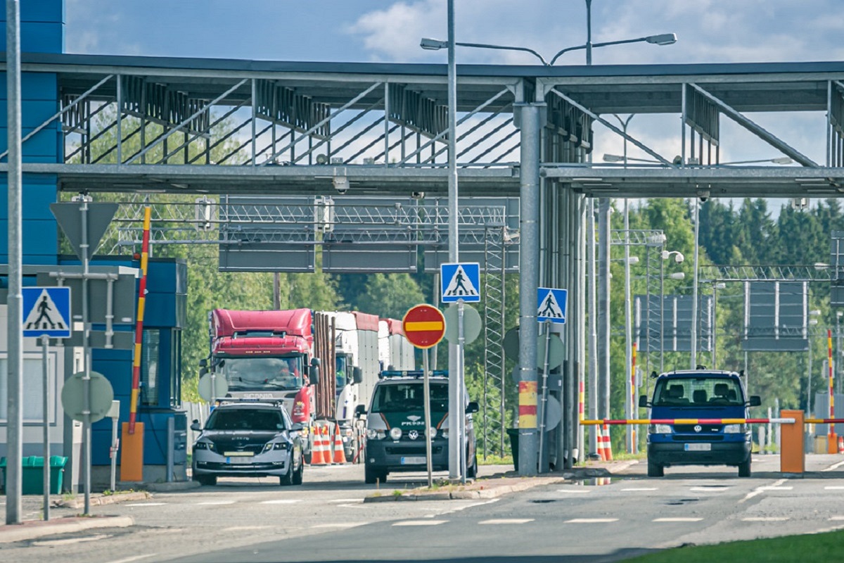 Långtradare köar vid östgränsens gränsövergångsställe med Gränsbevakningens och Tullens fordon i filerna.