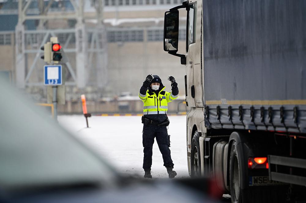 Tullitarkastaja ohjaa rekkaa tarkastettavaksi.